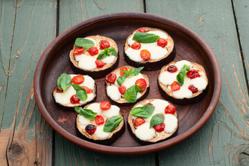 Italian mini pizza . Aubergine (eggplant ) with mozzarella cheese and basil . On rustic background