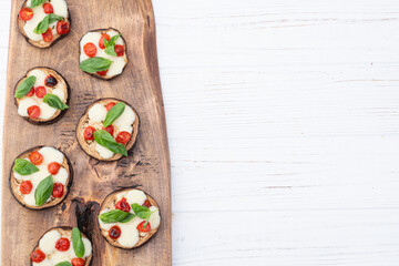 Italian mini pizza . Aubergine (eggplant ) with mozzarella cheese and basil . On rustic background