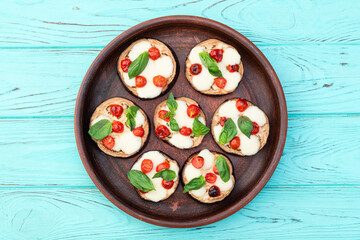 Italian mini pizza . Aubergine (eggplant ) with mozzarella cheese and basil . On rustic background