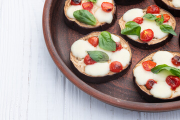 Italian mini pizza . Aubergine (eggplant ) with mozzarella cheese and basil . On rustic background