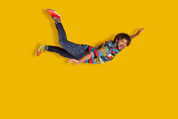 Full length photo of handsome young male flying excited dressed stylish colorful garment isolated...