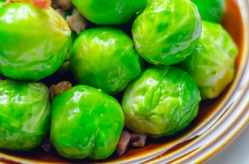 A plate of green brussels sprouts with bacon on top