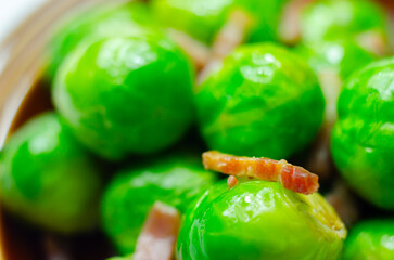A plate of green brussels sprouts with bacon on top