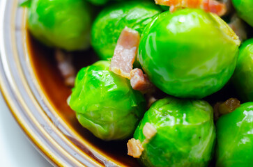 A plate of green brussels sprouts with bacon on top