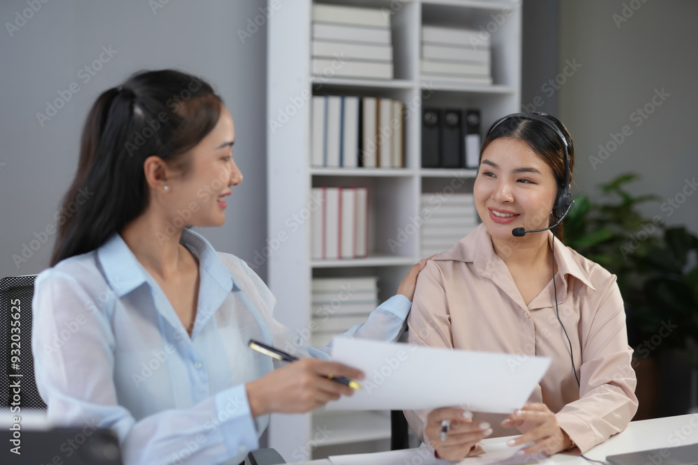 Poster manager comforting and assisting a smiling call center operator with a headset by giving her advice 