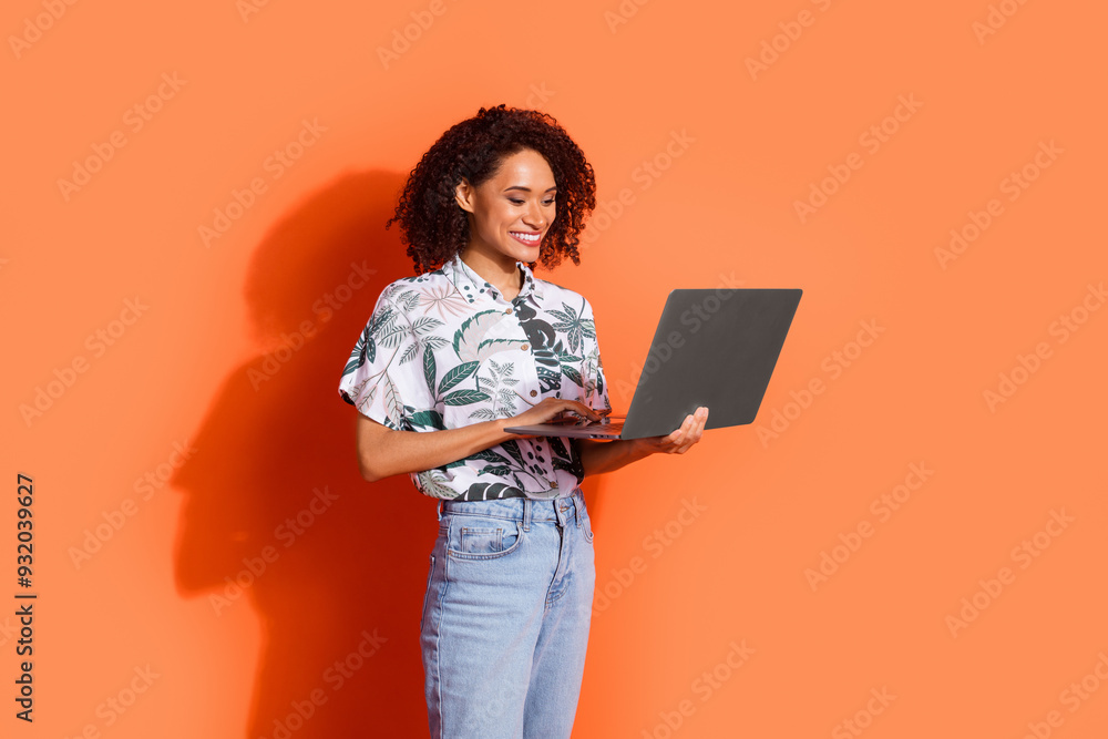 Sticker Photo portrait of young programmer funny woman in shirt working remote with laptop isolated on orange color background