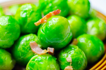 A plate of green brussels sprouts with bacon on top