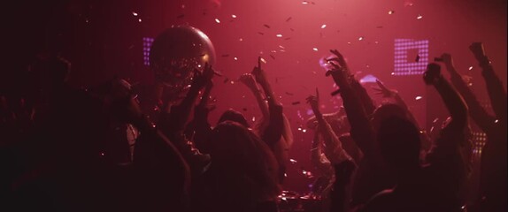 Extreme slow-motion shot of a group of people dancing happily with raised hands under falling confetti - Powered by Adobe