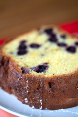 A piece of cake with currants on a plate.