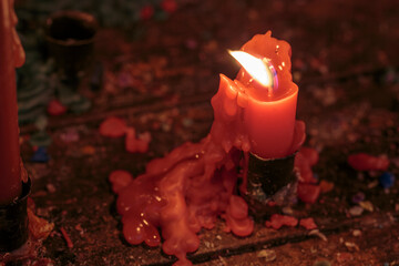 Single candle burning with melted wax on wooden surface