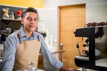 Barista leans on the counter and looks at the camera with a pleasant smile