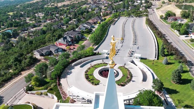 Aerial footage of the Angel Moroni golden statue atop Bountiful Utah Temple on a sunny day, USA