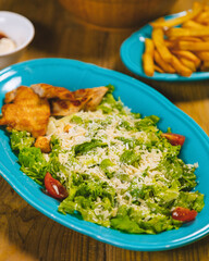 Delicious caesar salad with chicken served on turquoise plate