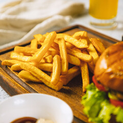 Delicious french fries resting on a wooden cutting board