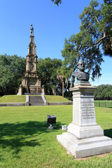 Statue of Lafayette McLaws with civil war confederate monument in background in Savannah, Georgia, USA