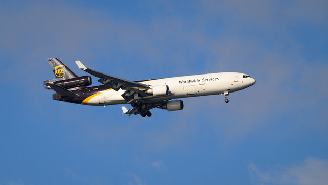 Seattle - August 18, 2024; UPS United Parcel Service livery Boeing McDonnell Douglas MD 11 tri jet flying  against blue sky with wheels down for landing N260UP