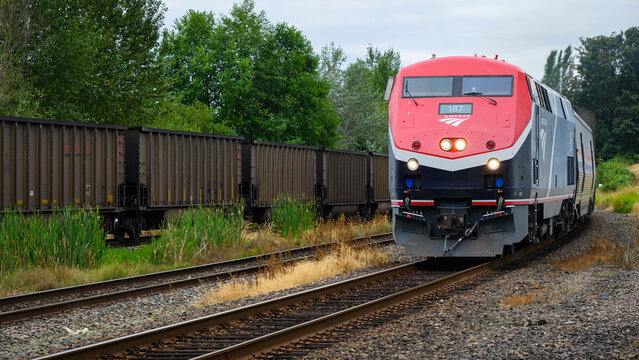 Everett, WA, USA - July 28, 2024; Amtrak Empire Builder train passing freight train with headlights