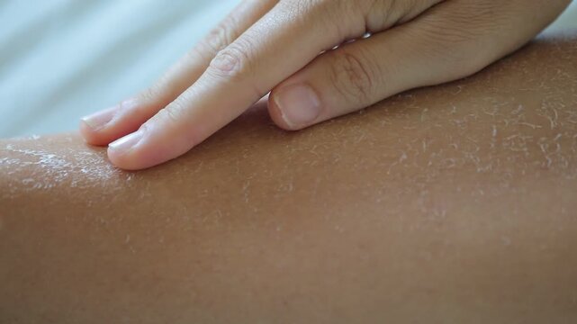 Female hand caressing dry skin on leg