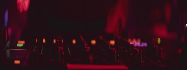 Close-up of DJ hands mixing music using control buttons on professional turntable deck console in night club