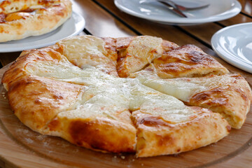 traditional Georgian bread with cheese known as imeruli khachapuri plate in close up on table