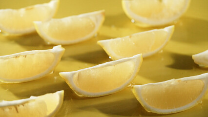 Macro of a fresh lemon slices arranged on yellow background. Close up of citrus fruit or lemon sliced placed at red backdrop. Citrus composition concept. Design for greeting card, wallpaper. Pabulum.