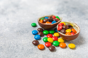 Easter chocolate egg on textured background. Easter celebration concept. Easter chocolate rabbit. Chocolate sweet eggs. Candies on textured wooden table. Space for text.Copy space. Gift. Banner.