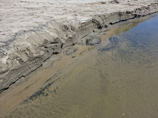 close-up view of the sandy shore of a watercourse
