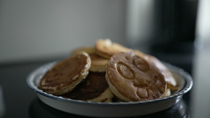 Close-up of a plate of smiley face pancakes stacked high. The detailed shot showcases a fun and delightful breakfast treat, emphasizing creativity and joy in food presentation