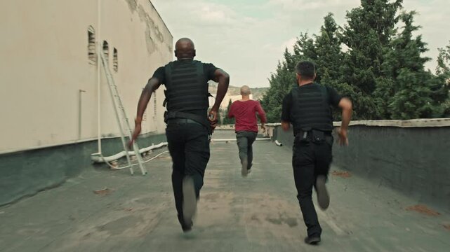 Back view of Suspect running away from the police in the city