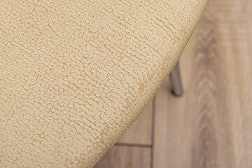 Damaged leather upholstery of the chair closeup. Artificial leather