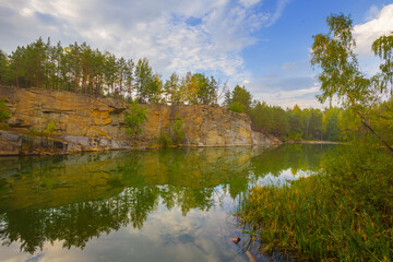 calm lake with forest on rocky coast