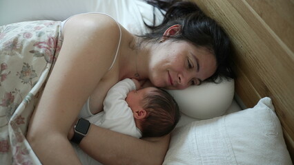 Mother lying in bed with newborn baby, cozy and intimate moment, mom watching over sleeping infant, serene family bonding, peaceful early morning, maternal love, nurturing environment, tender care