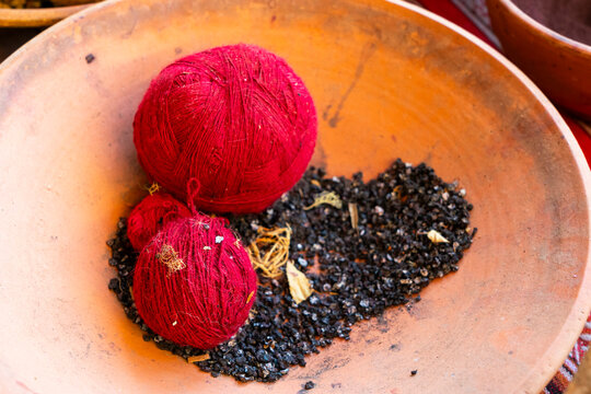 Red balls of wool and cactus insects as natural dye, Chinchero, Sacred Valley, Urubamba Province, Cusco (Cuzco) Region, Peru