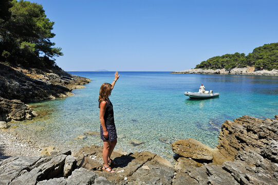 Woman standing on rocks at a creek of Mrcara islet at the north-west of Lastovo island, Croatia, Southeast Europe