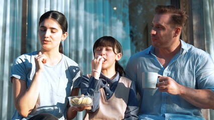 Lovely marriage couple and daughter picnic at outdoor terrace. Family using outdoor activity show love and care to strengthen good growth for child, strong family bond or relationship. Divergence.
