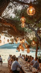 Guests gather around a long table adorned with lanterns and plates, enjoying an outdoor dinner as the sun sets over the tranquil water