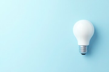 A solitary lightbulb rests against a calming blue backdrop, symbolizing creativity and inspiration in a simple yet elegant manner.