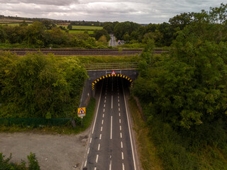 Aerial view of a road passing under a railway bridge in the british countryside