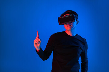 Profile man wearing VR headset looking to connect metaverse pointing product banner advertisements isolated neon light blue background futuristic virtual reality 3D innovation simulation. Contrivance.