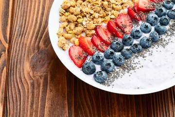 Healthy breakfast . Yogurt with berries ( strawberry , raspberry , blueberry , blackberry ) , granola and chia seeds . Top view