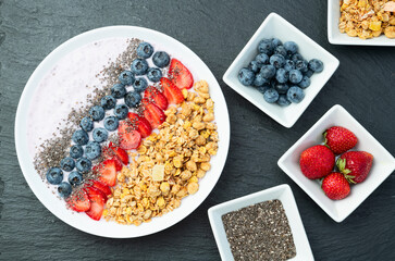 Healthy breakfast . Yogurt with berries ( strawberry , raspberry , blueberry , blackberry ) , granola and chia seeds . Top view