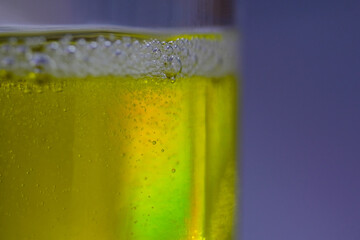 Air bubbles in thick yellow water in clear glass