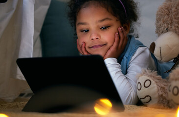 Girl, child and tablet for watching movie at night in home, fort and teddy bear for friendship. Female person, kid and online subscription for streaming cartoon series, internet video and relax - Powered by Adobe