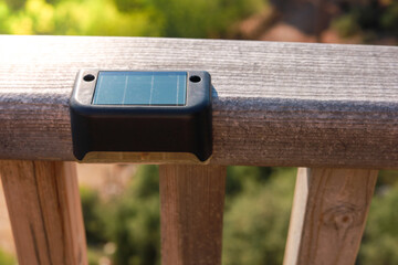 Small solar powered led light with motion sensor on wooden terrace