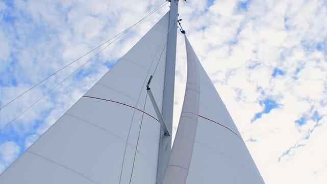 Colorful yacht sails were captured up close, highlighting their details against clear blue sky, enhancing exhilarating sense of adventure and freedom while sailing on vast ocean