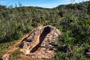 Granite rock cut anthropomorphic grave in Vale Fuzeiros at Vilarinha, Algarve, Portugal.