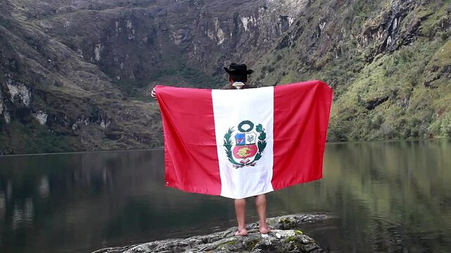 Campesino con Poncho y Sombrero Flamea la Bandera del Per&uacute; en la Laguna.