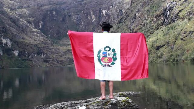 Campesino con Poncho y Sombrero Flamea la Bandera del Per&uacute; en la Laguna.