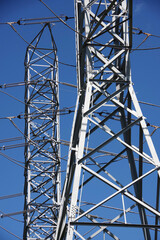 High voltage electricity towers under blue sky