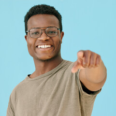 Glasses, pointing and portrait with black man on blue background in studio for announcement or...